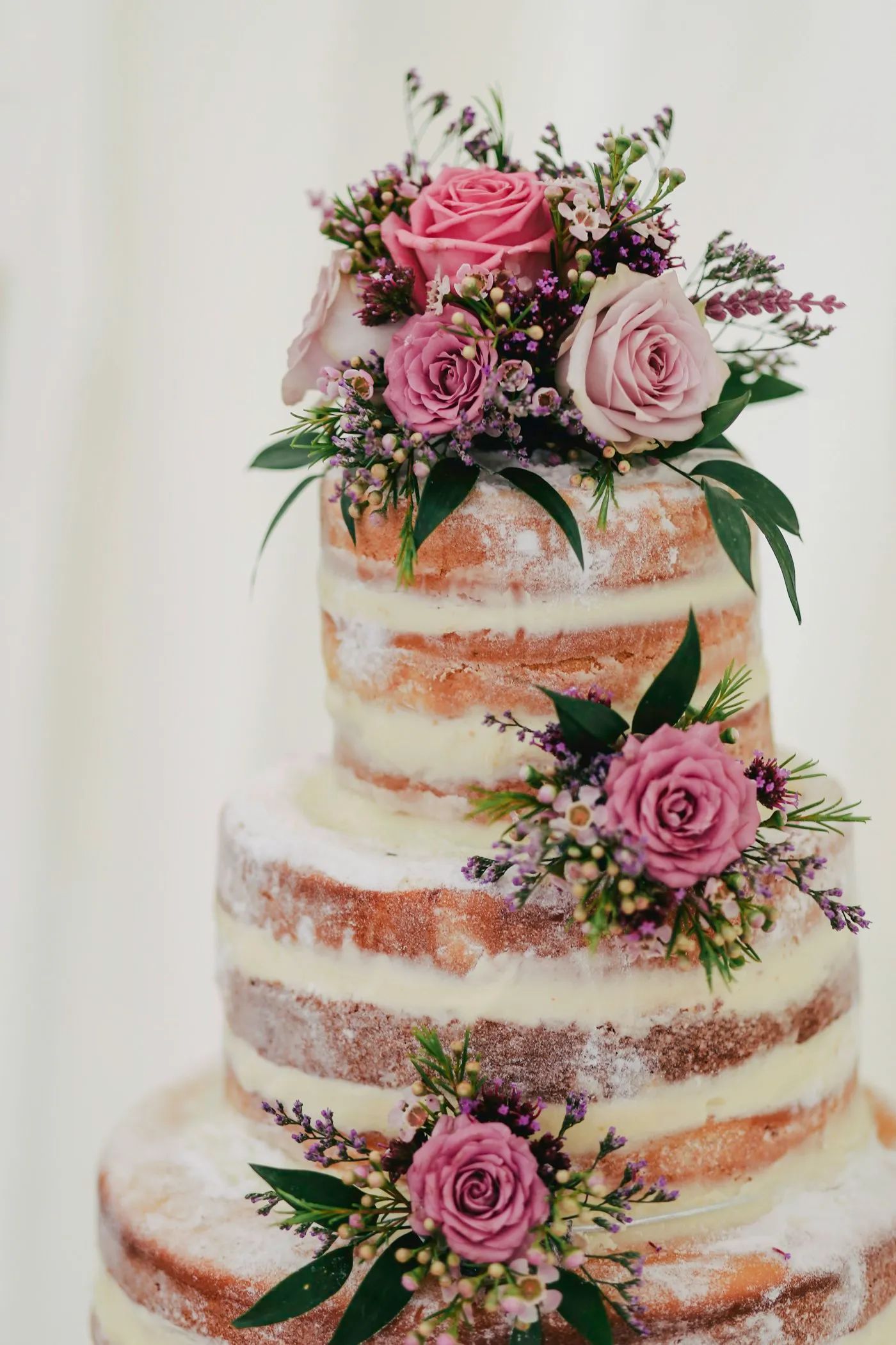 Three-tier cake covered in colourful piped buttercream wildflowers.