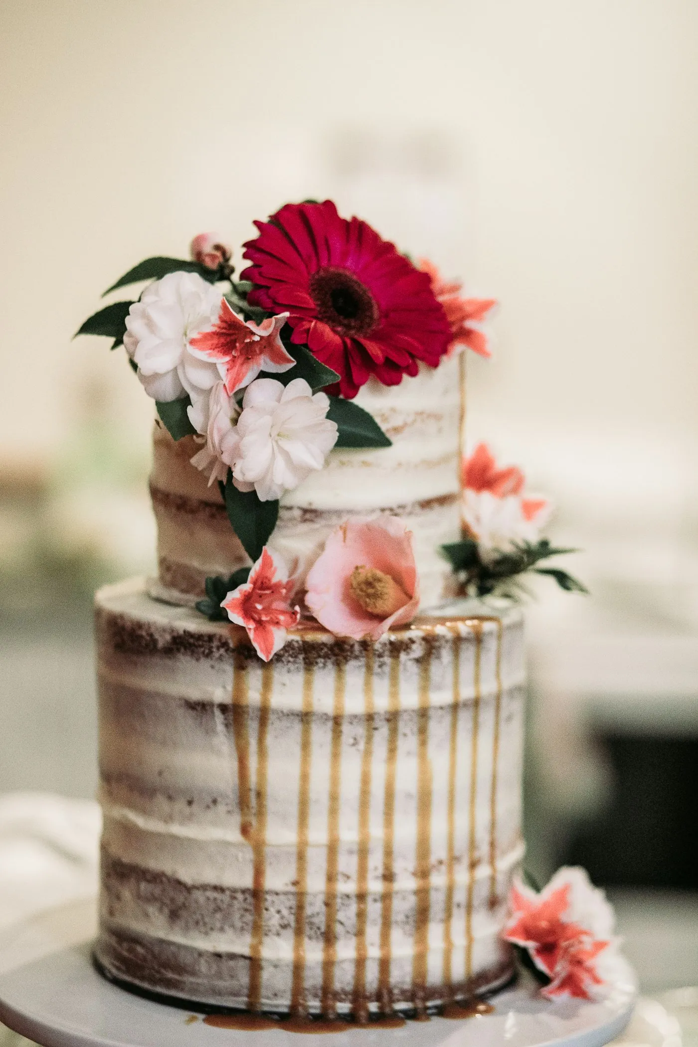 White iced cake with a spray of flowers at the top.